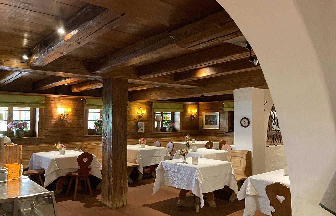 Holzbalken-Gaststube mit weiß gedeckten Tischen
