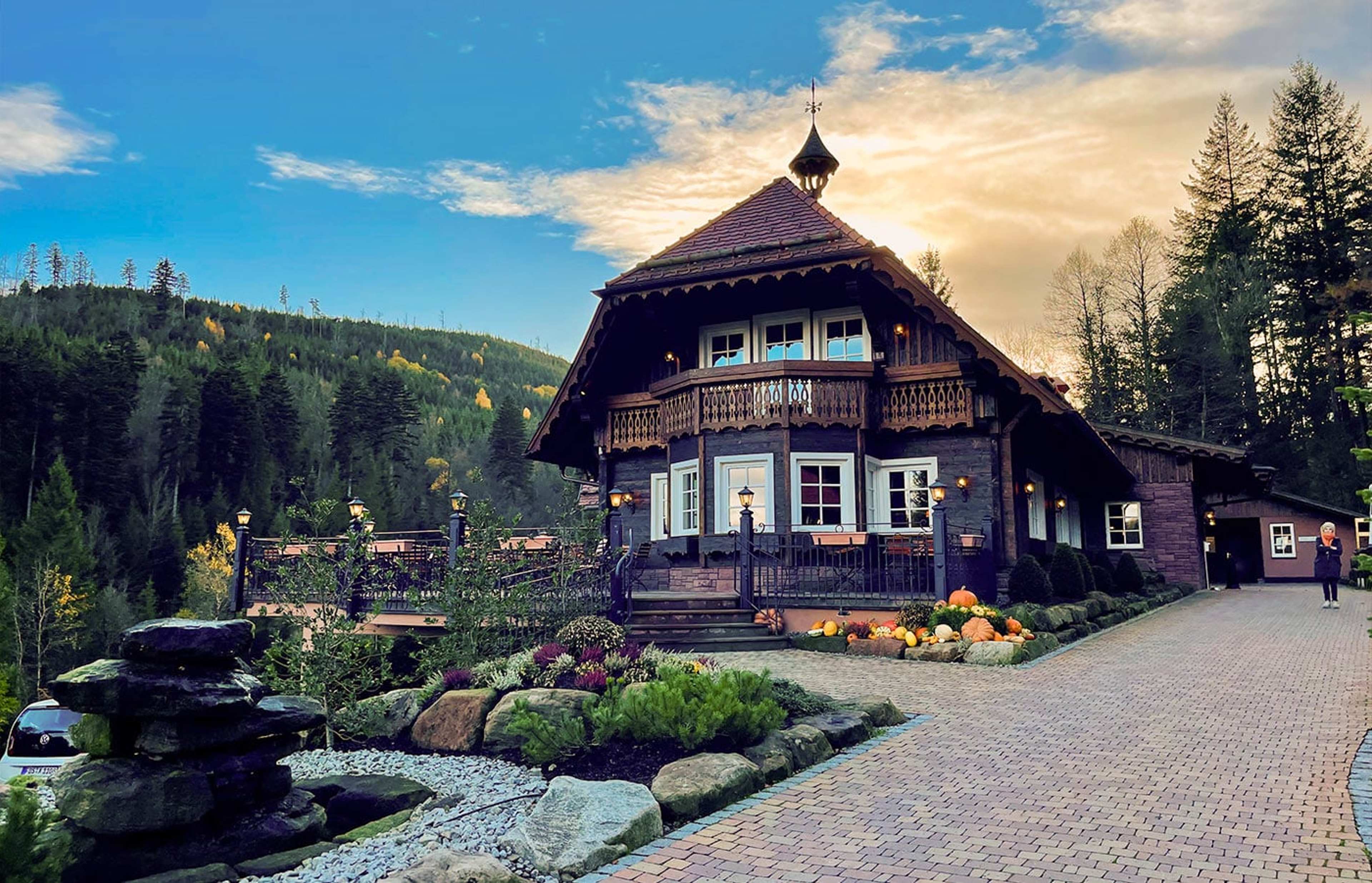 Schwarzwaldhaus mit Türmchen in einem Tal mit Tannen