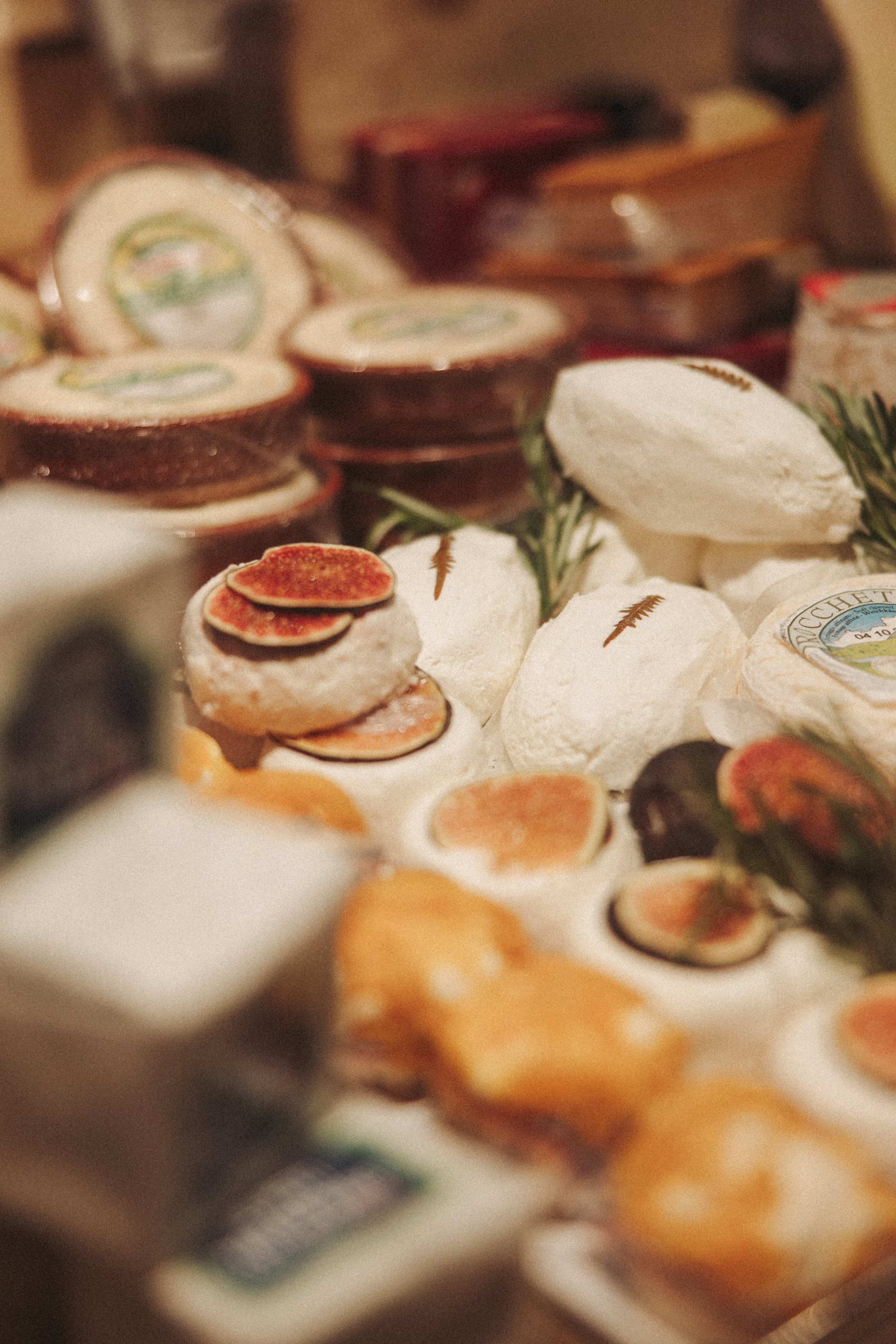 Kleine weiße Käse mit Feigenscheiben in der Käsetheke, der Vordergrund unscharf