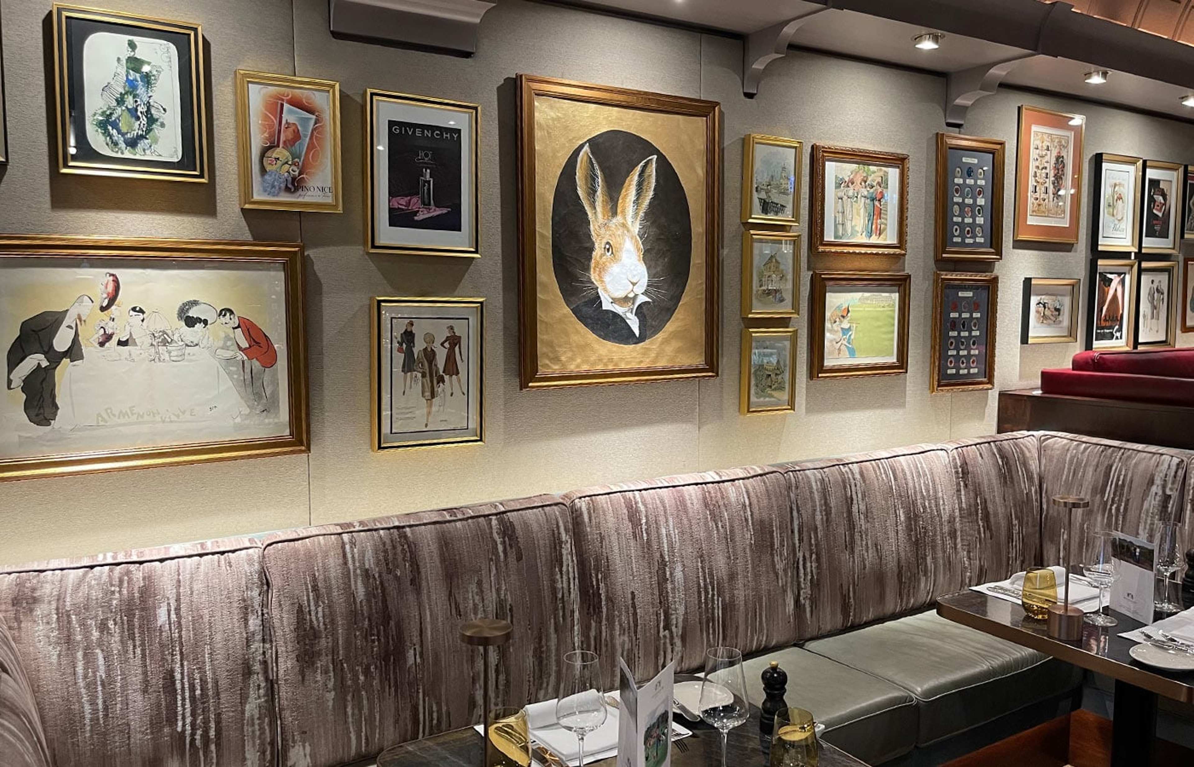 Bar mit gemusterter Polsterbank und vielen gerahmten Bildern an der Wand