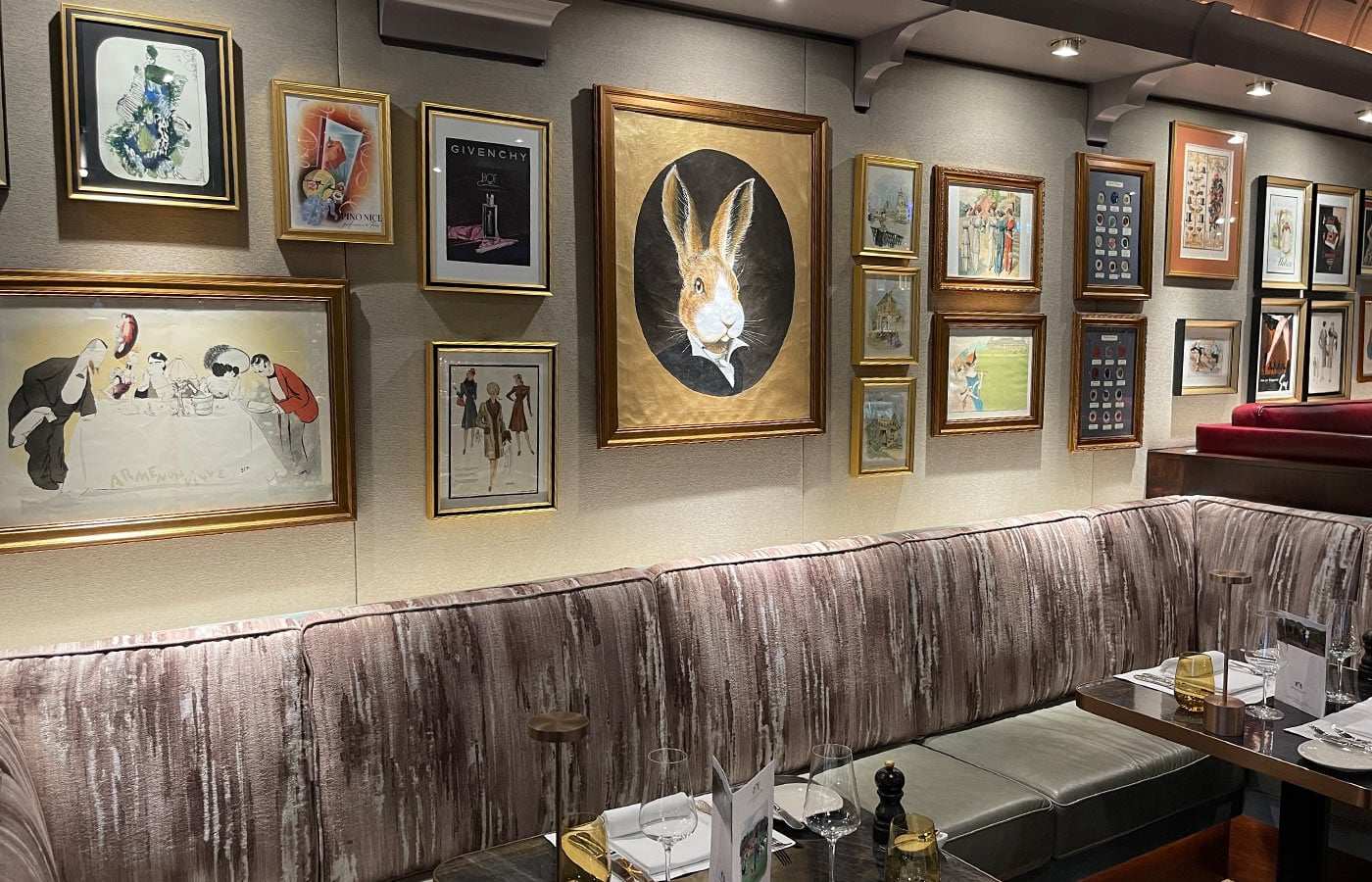 Bar mit gemusterter Polsterbank und vielen gerahmten Bildern an der Wand
