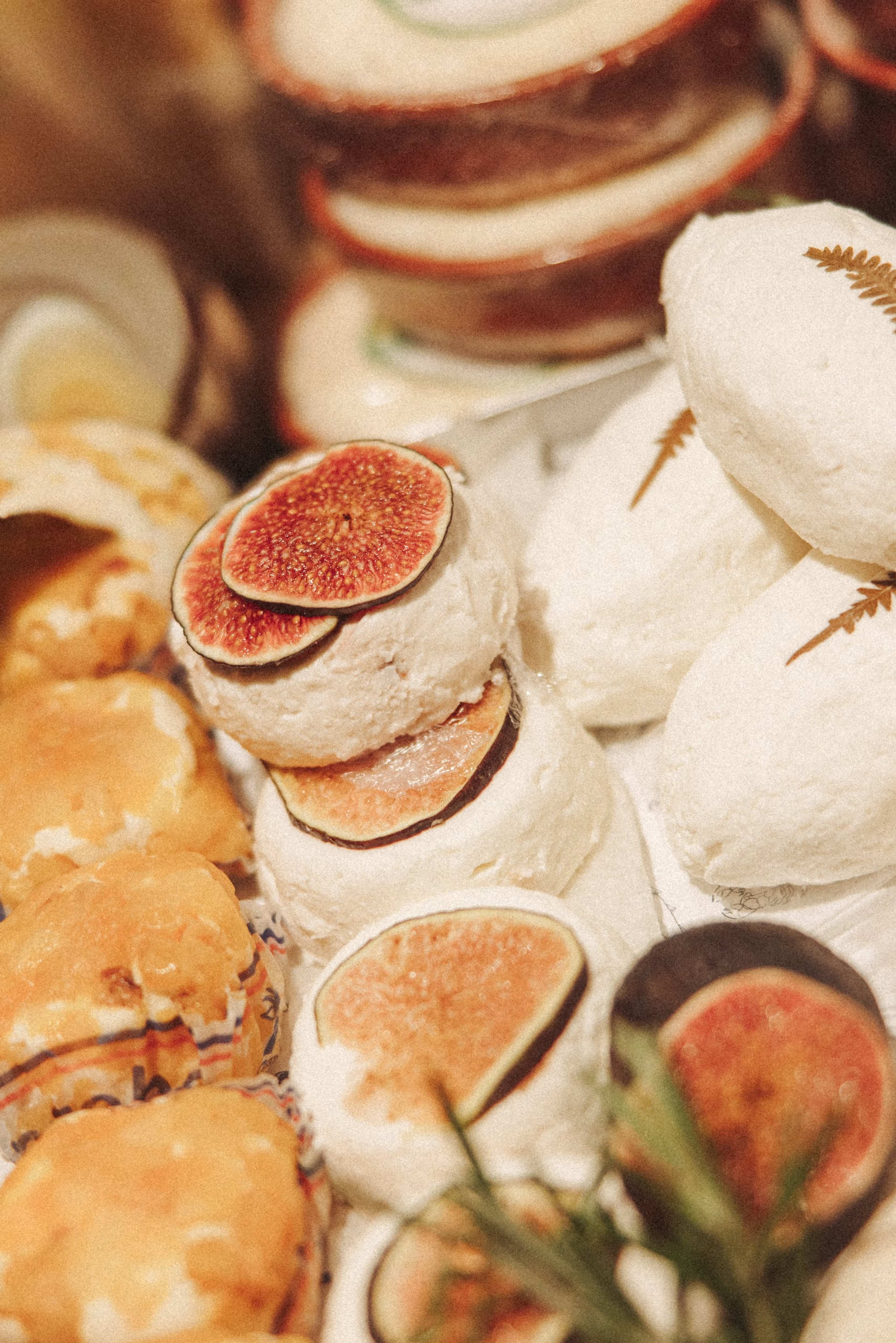 Kleine weiße Käse mit Feigenscheiben und Rosmarin dicht an dicht in der Käsetheke