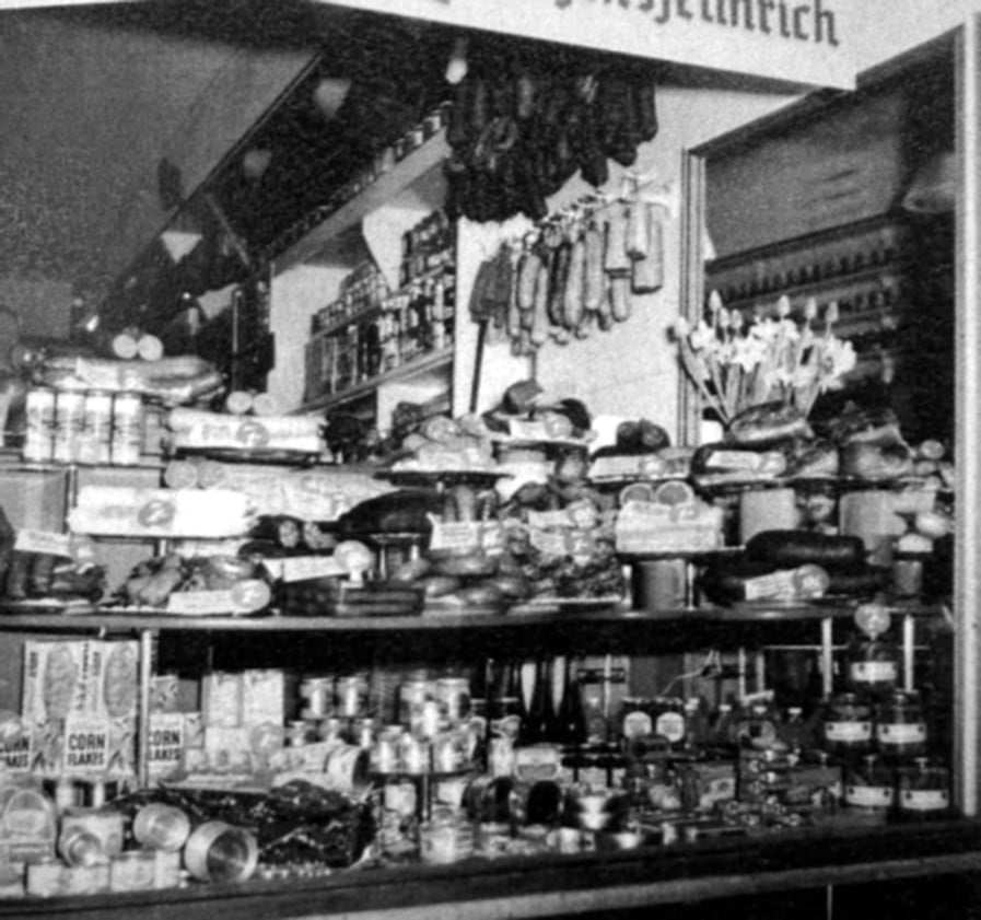 Aus dem Familienbuch: historischer Laden mit Wurst, Konserven und Lebensmitteln in den Regalen, schwarzweiß